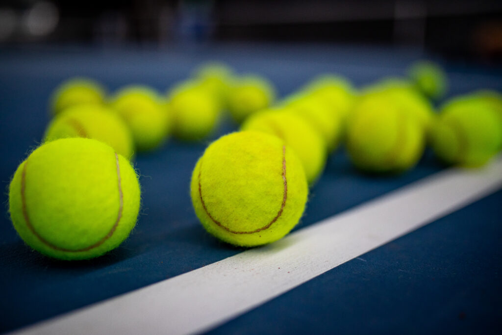Tennisbälle auf weißer Linie eines Tennisplatzes
