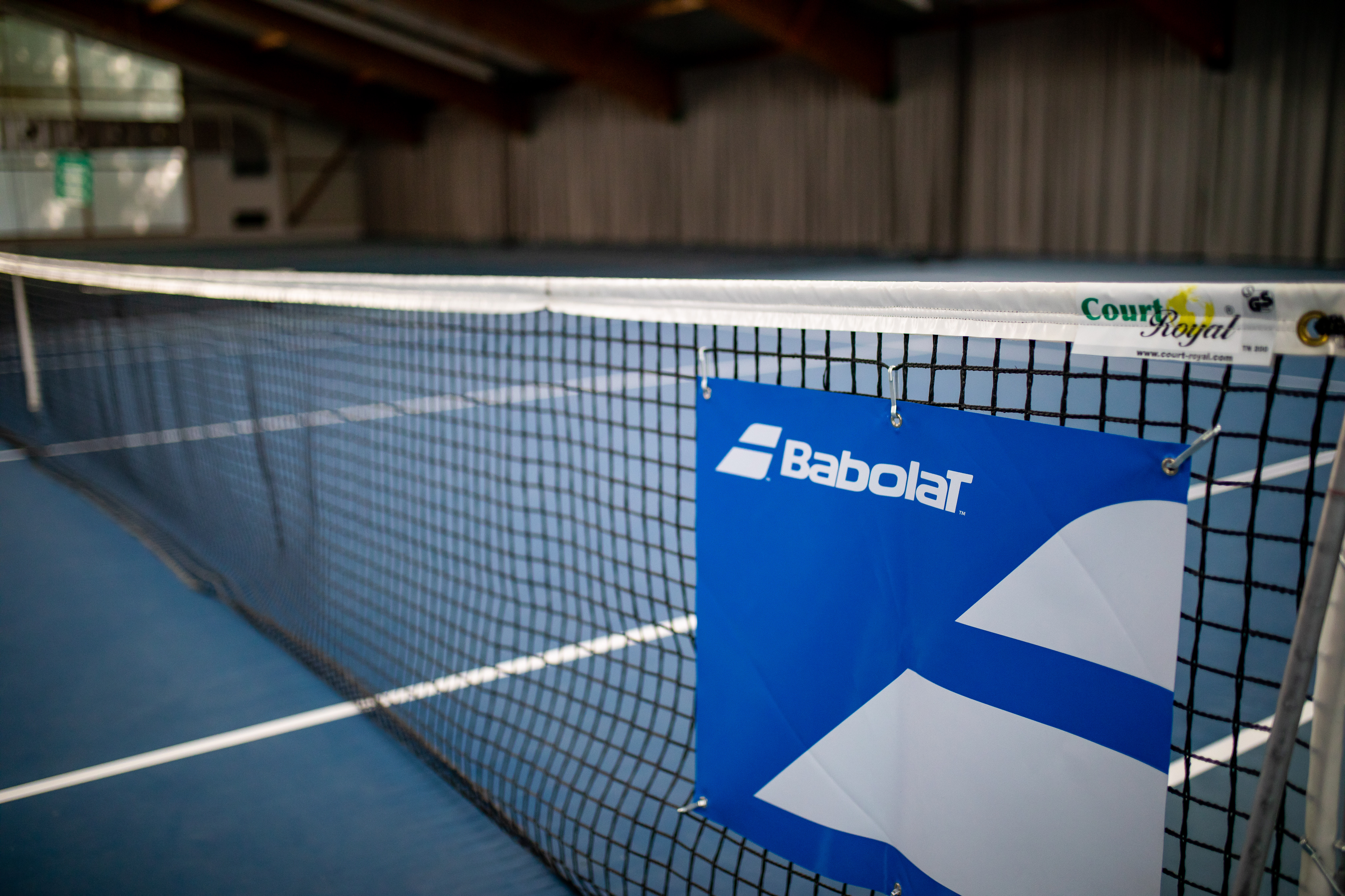 Tennisnetz in Halle mit Babolat-Schild