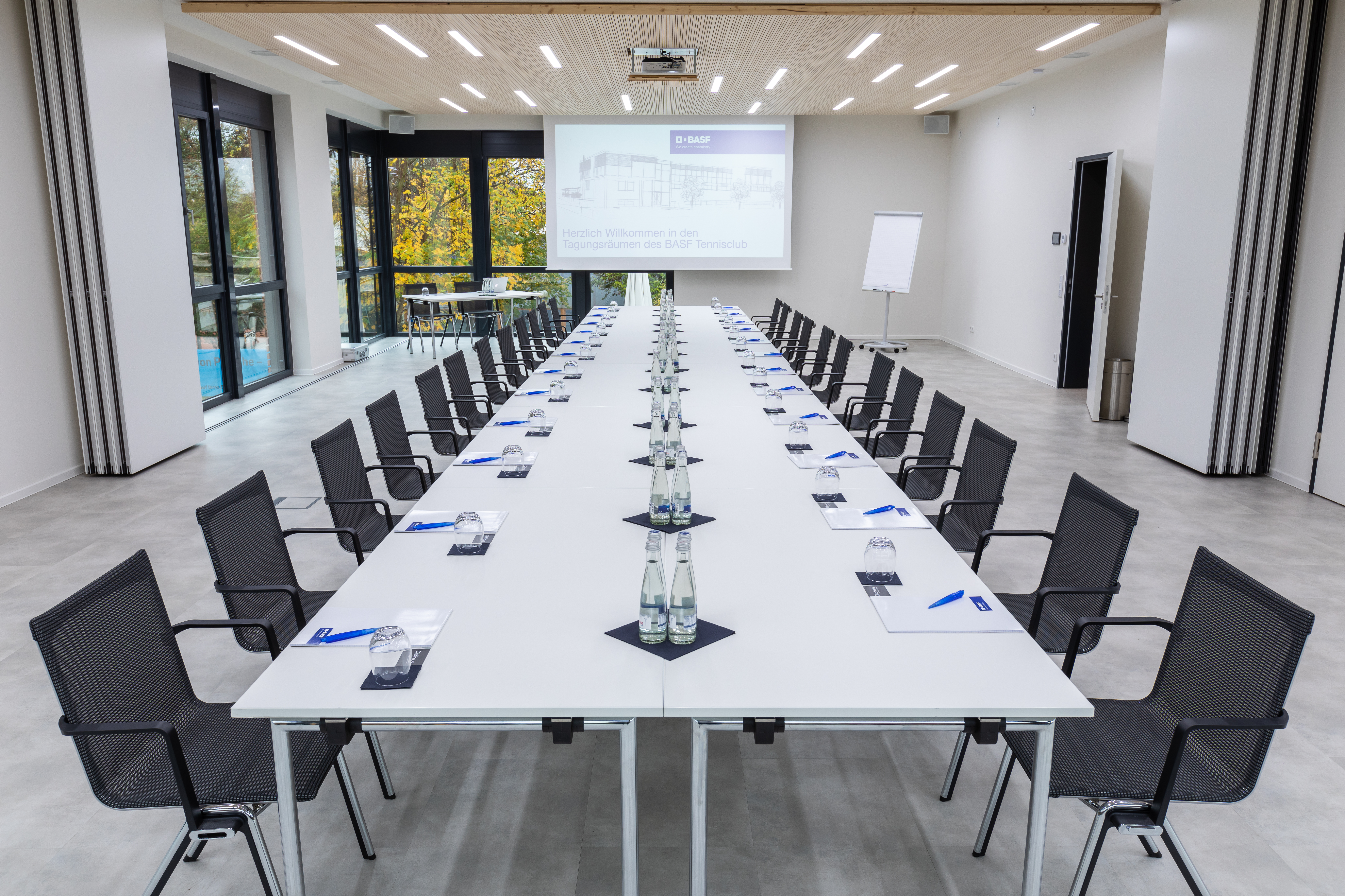 Moderner Konferenzraum mit langer Tafel und Beamer