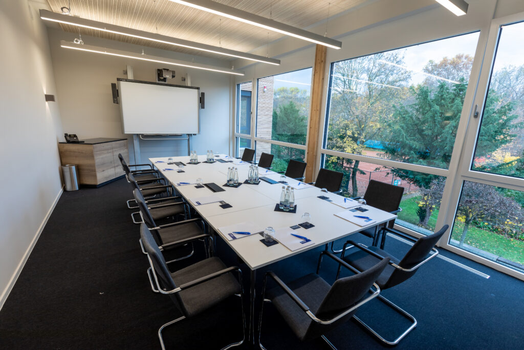 Moderner Konferenzraum mit großem Tisch und Fensterfront