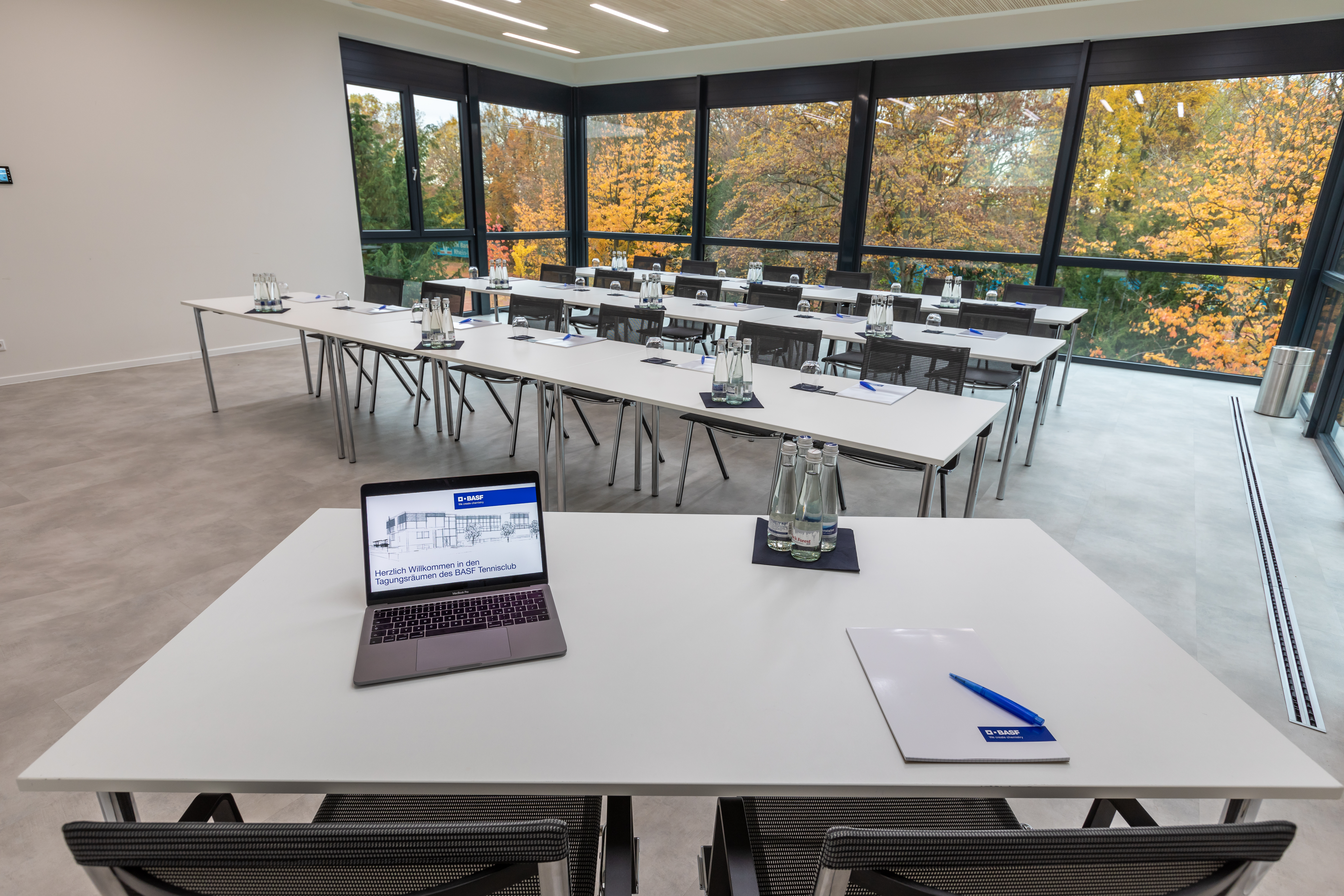 Moderner Konferenzraum mit großen Fenstern und Herbstblick