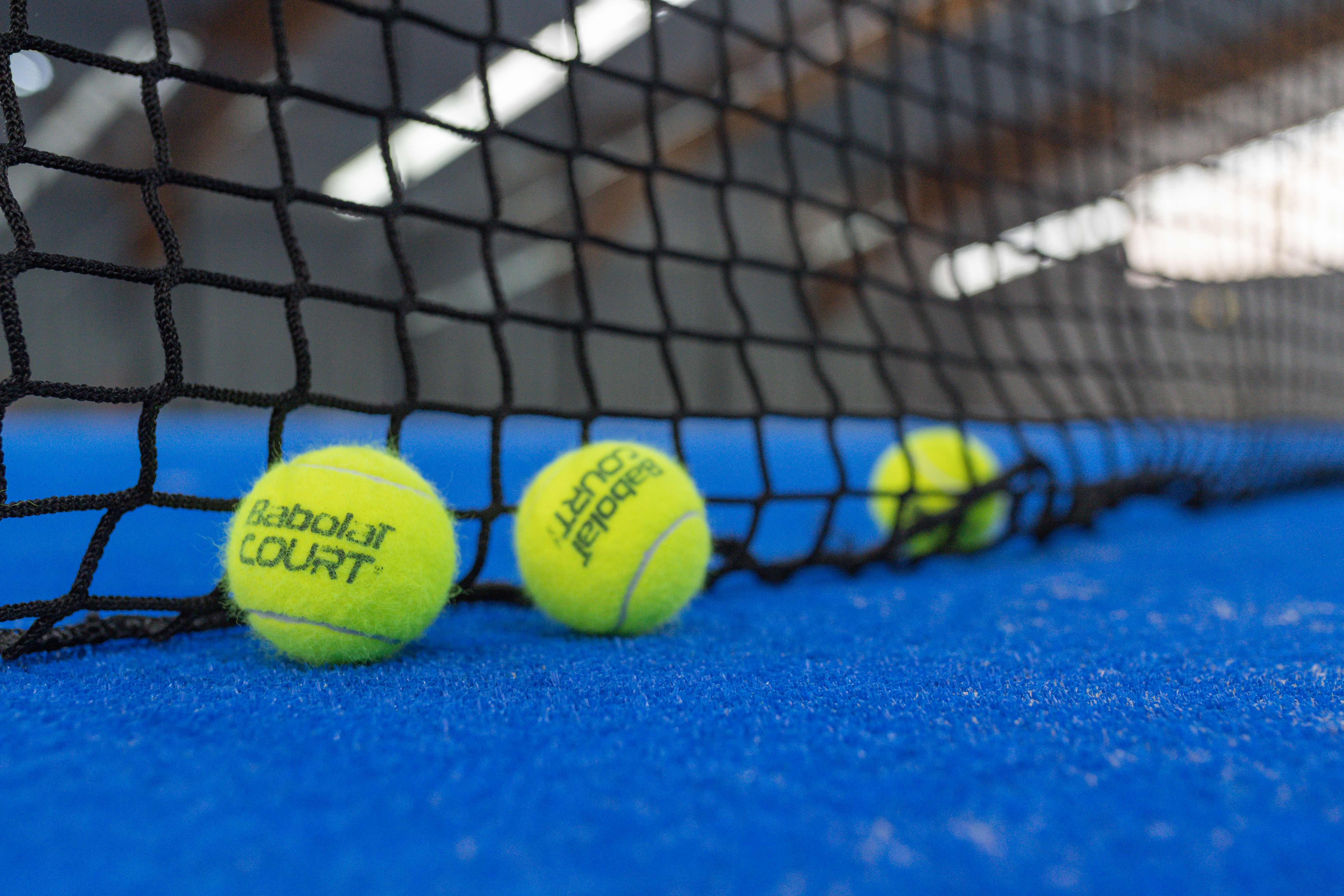 TennisbÃ¤lle am Netz auf blauem Tennisplatz