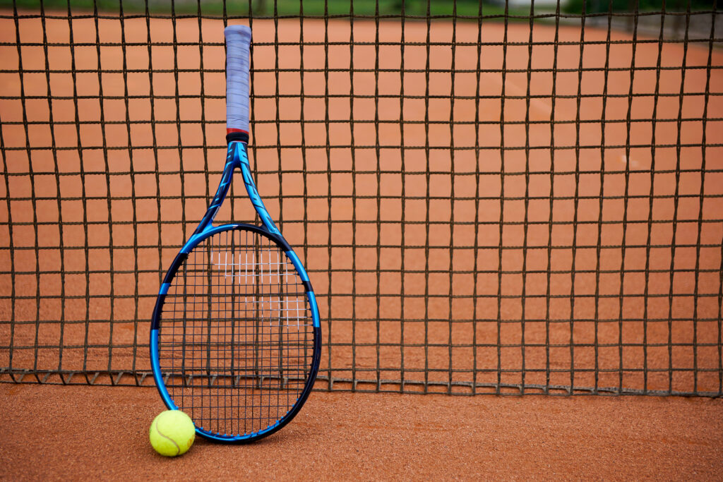 Tennis racket and ball on clay court