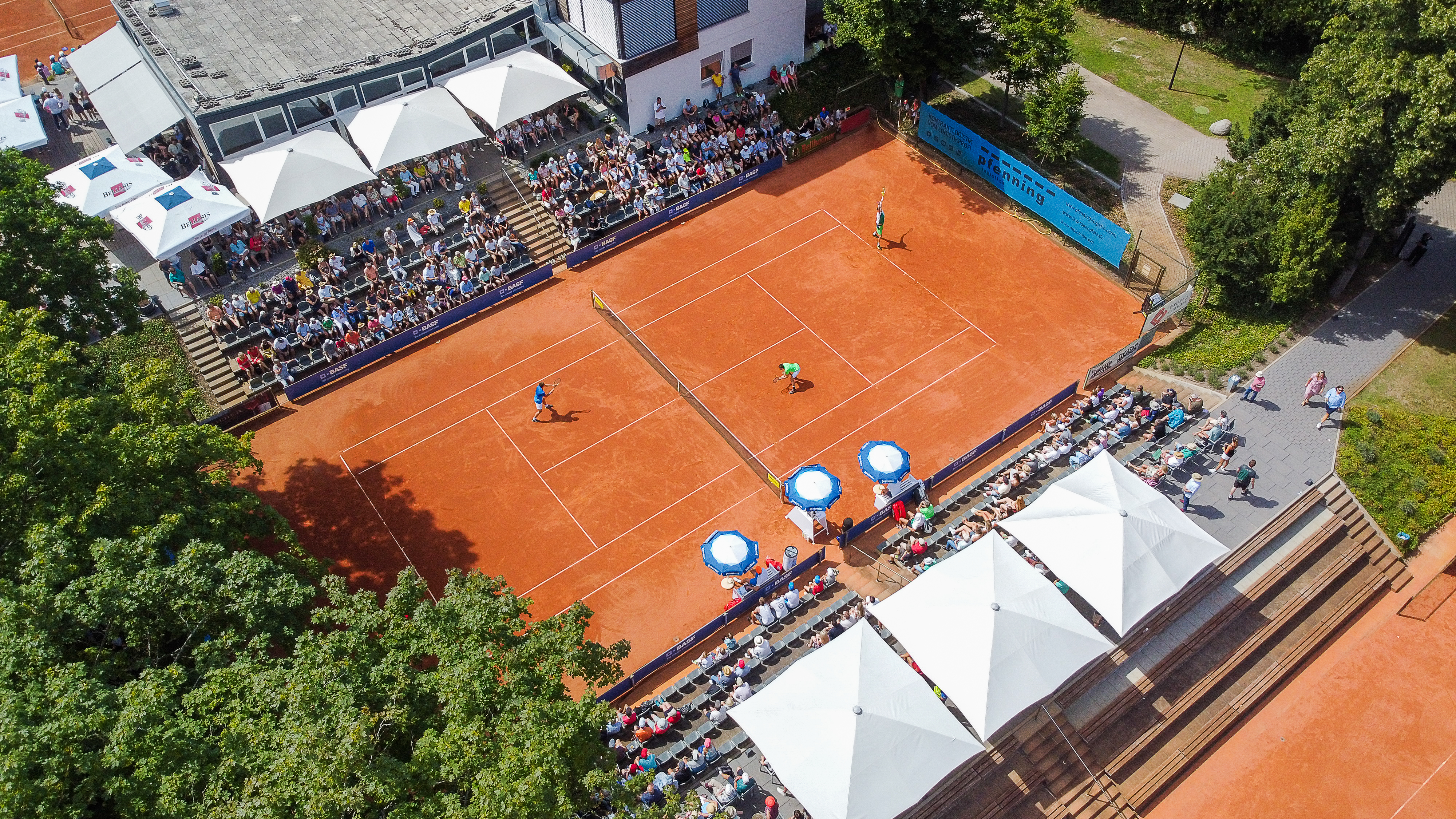 Luftaufnahme eines Tennisspiels auf Sandplatz