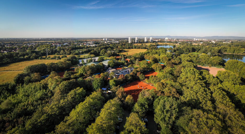Aerial view of tennis courts in lush park