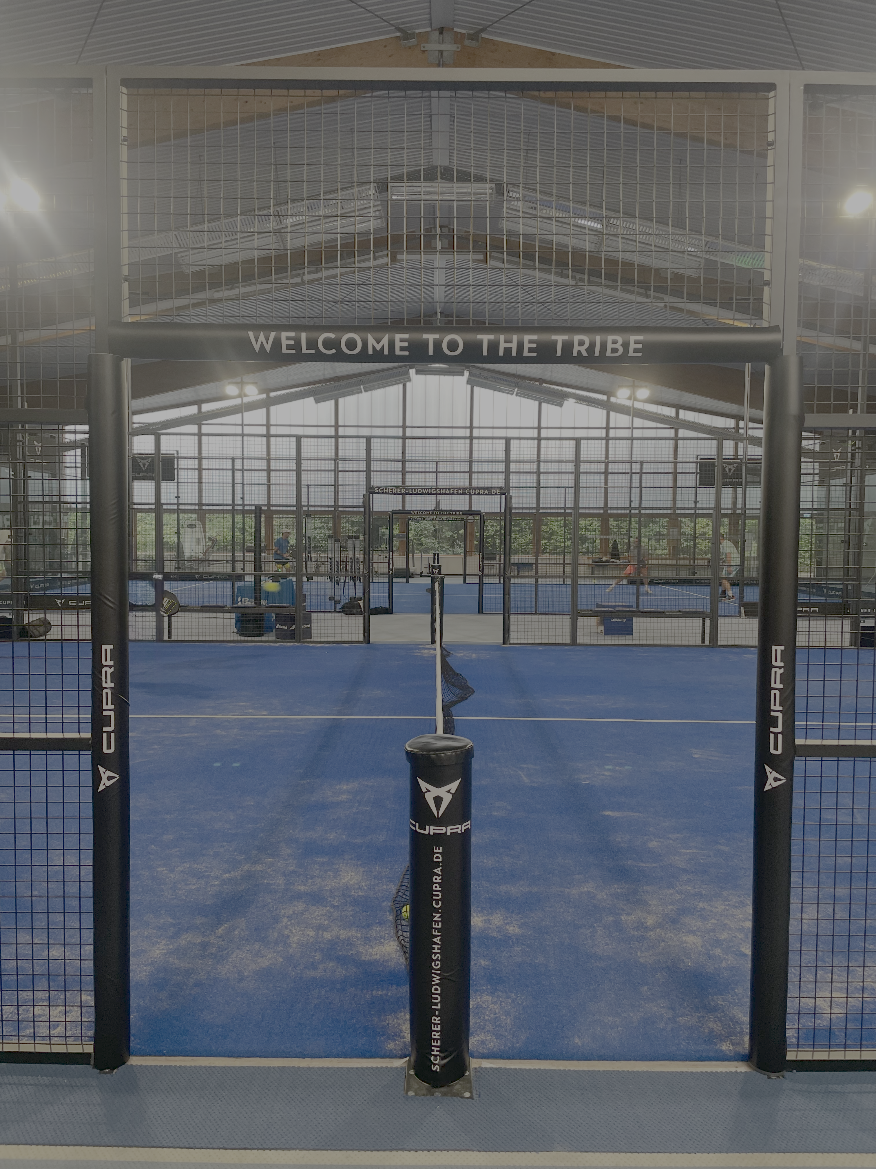 Indoor-Padelplatz mit blauem Boden und Netz