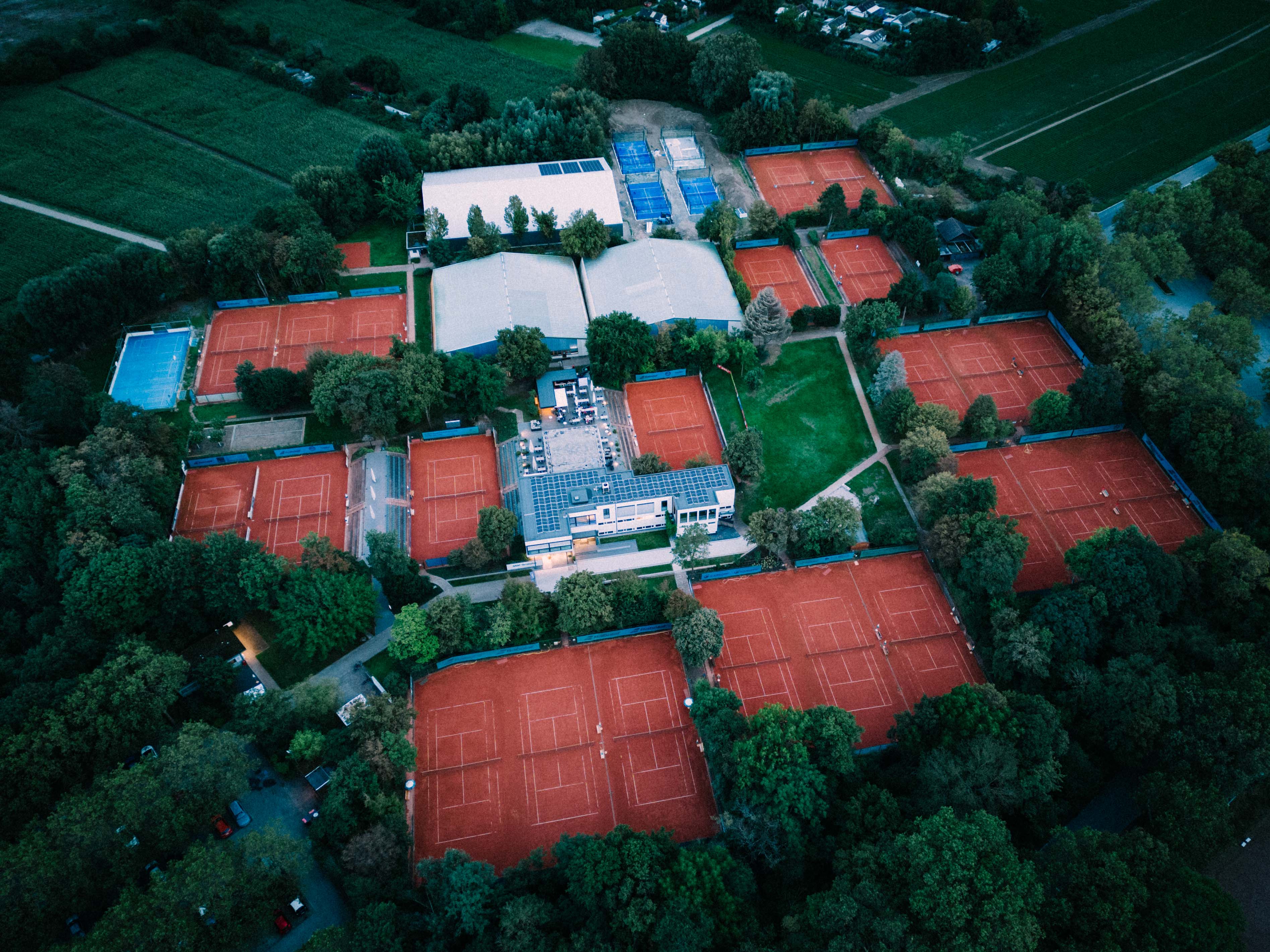 Luftaufnahme einer Tennisanlage mit zahlreichen Sandplätzen