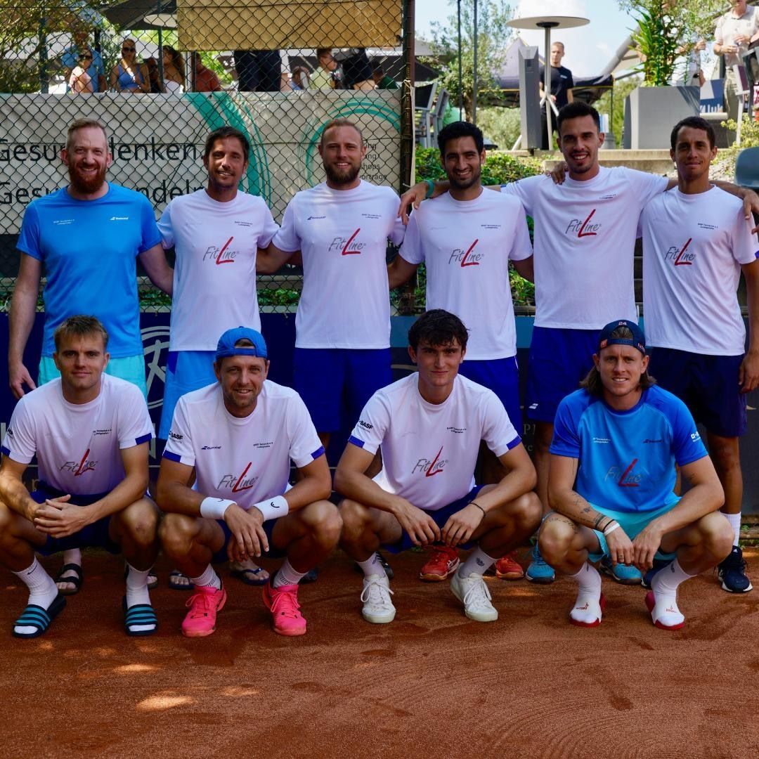 Tennismannschaft posiert auf Sandplatz im Freien