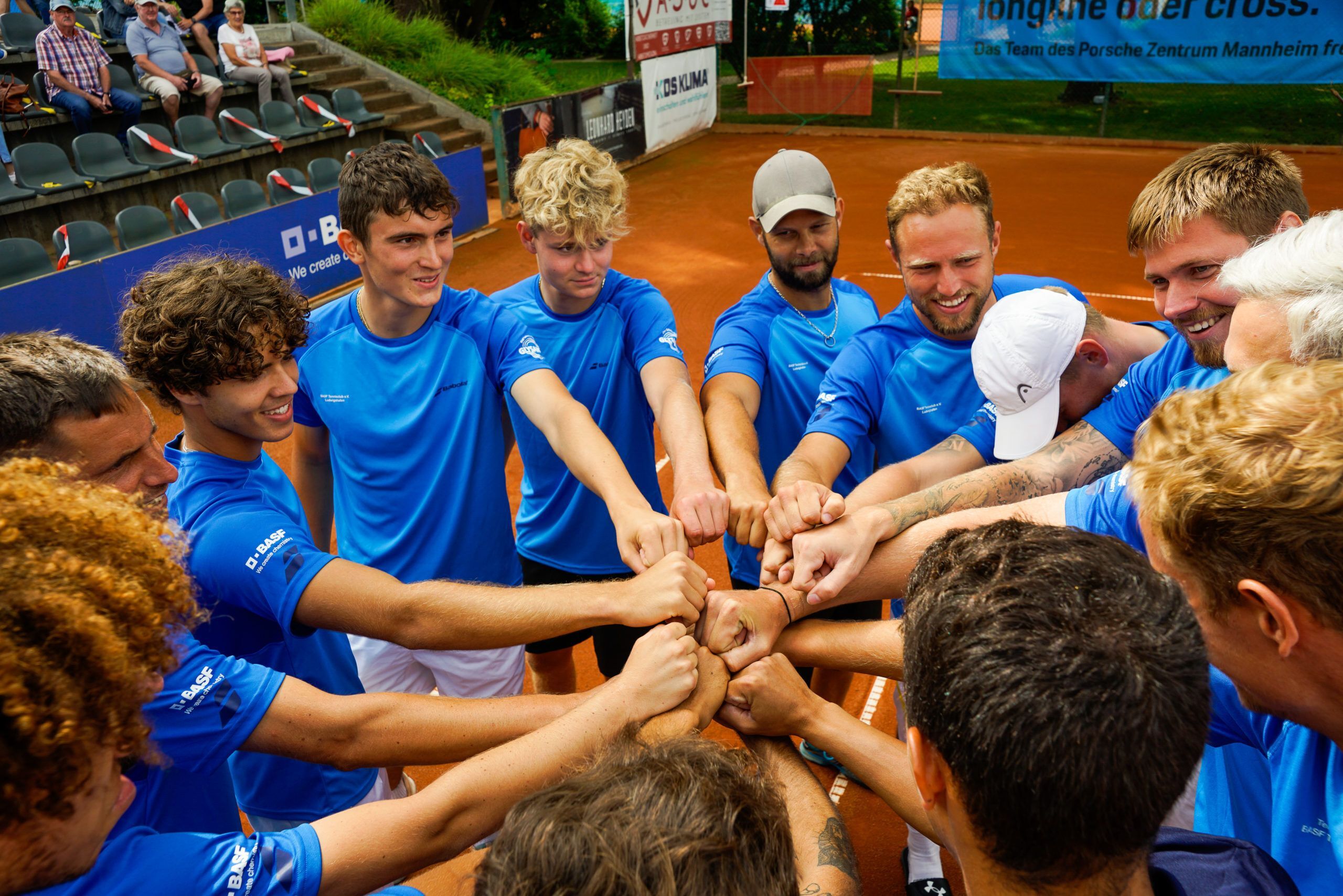 Tennismannschaft im Kreis mit geballten Fäusten