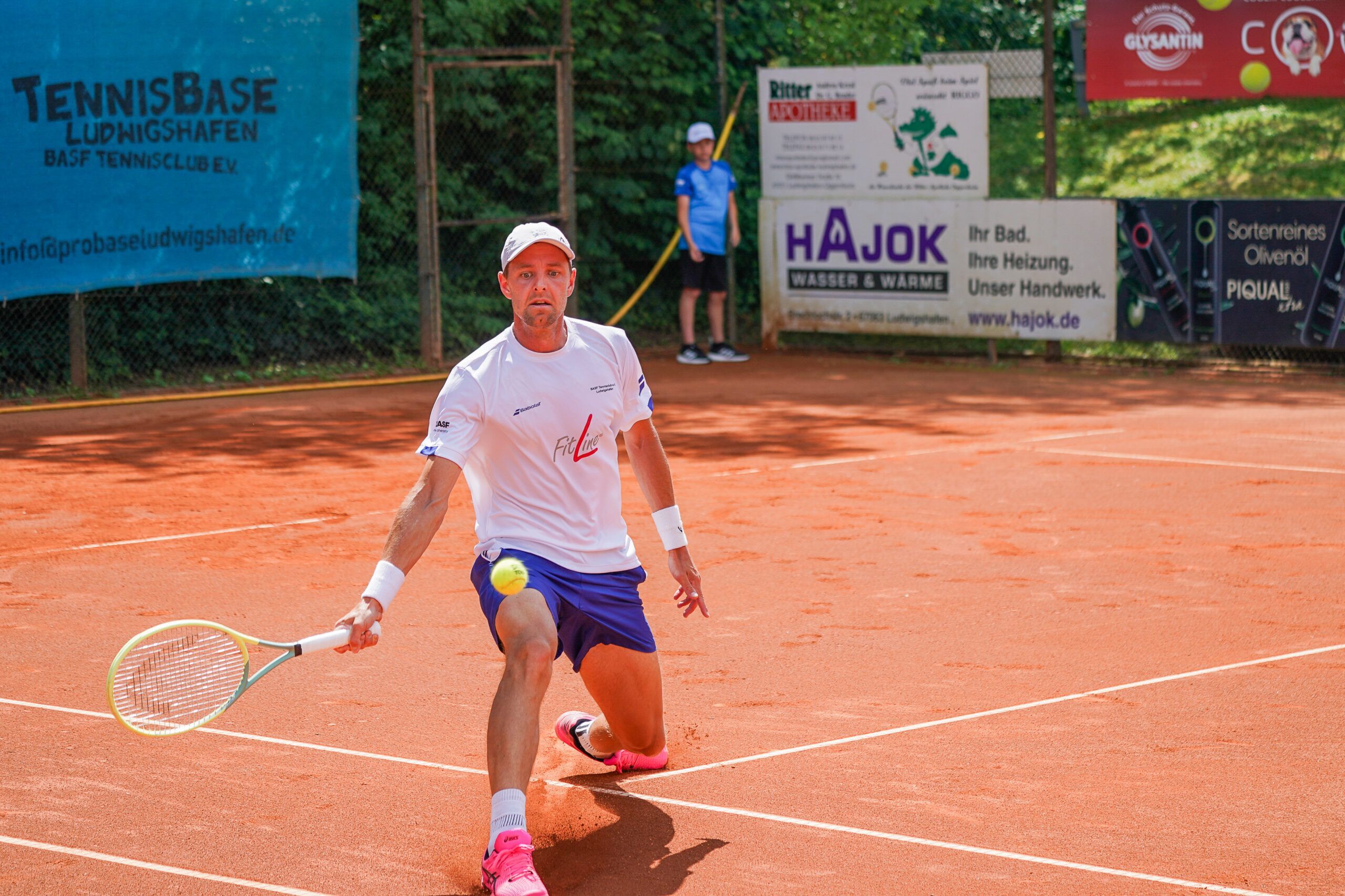 Tennisspieler auf Sandplatz beim Rückhandschlag