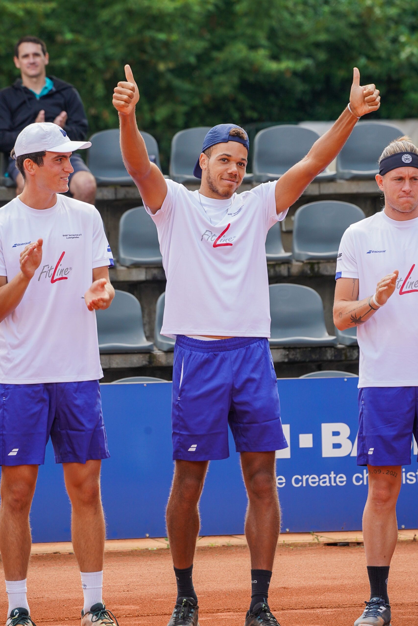 Tennisspieler hebt beide Daumen auf dem Platz