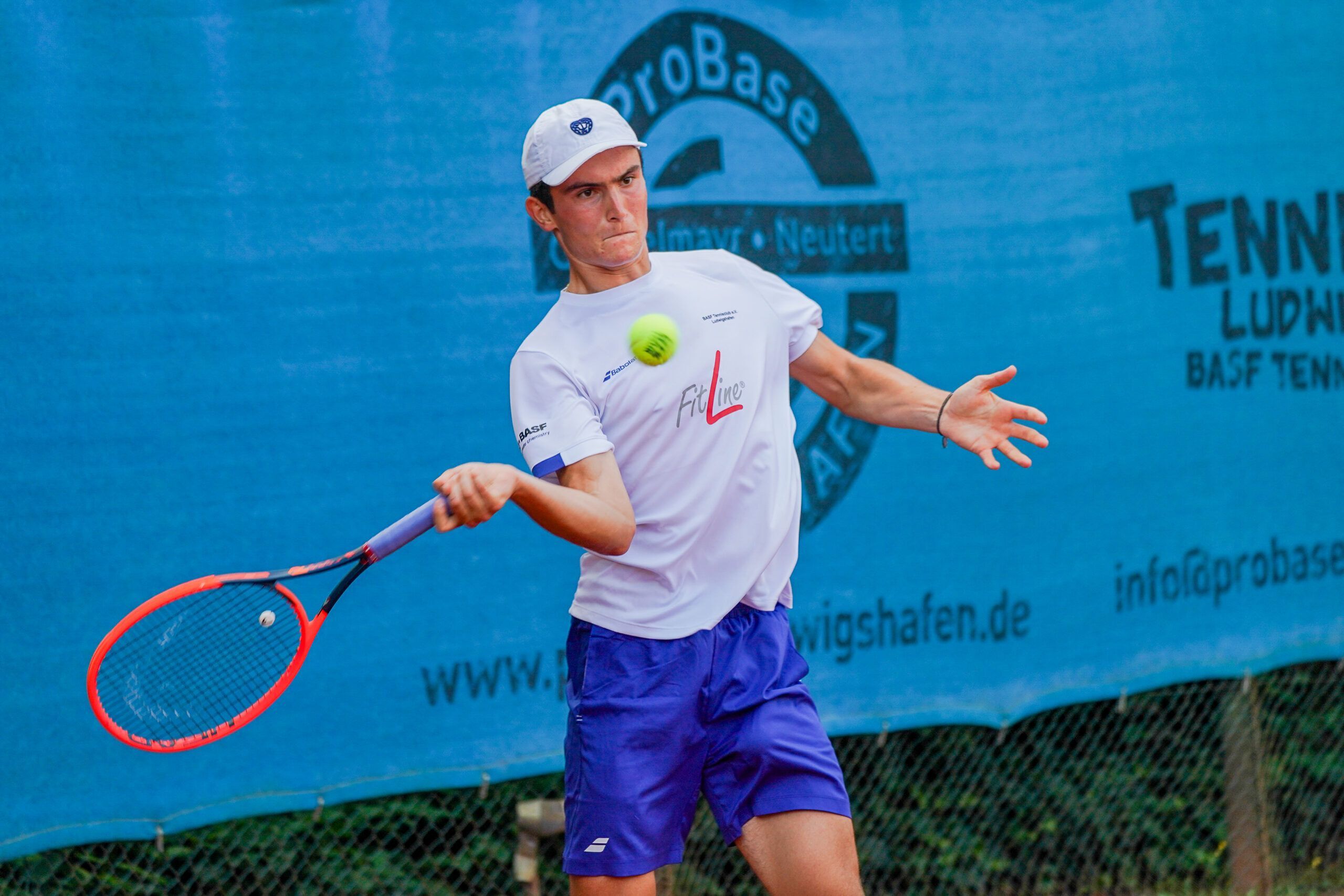 Tennisspieler schlägt Vorhand auf Sandplatz