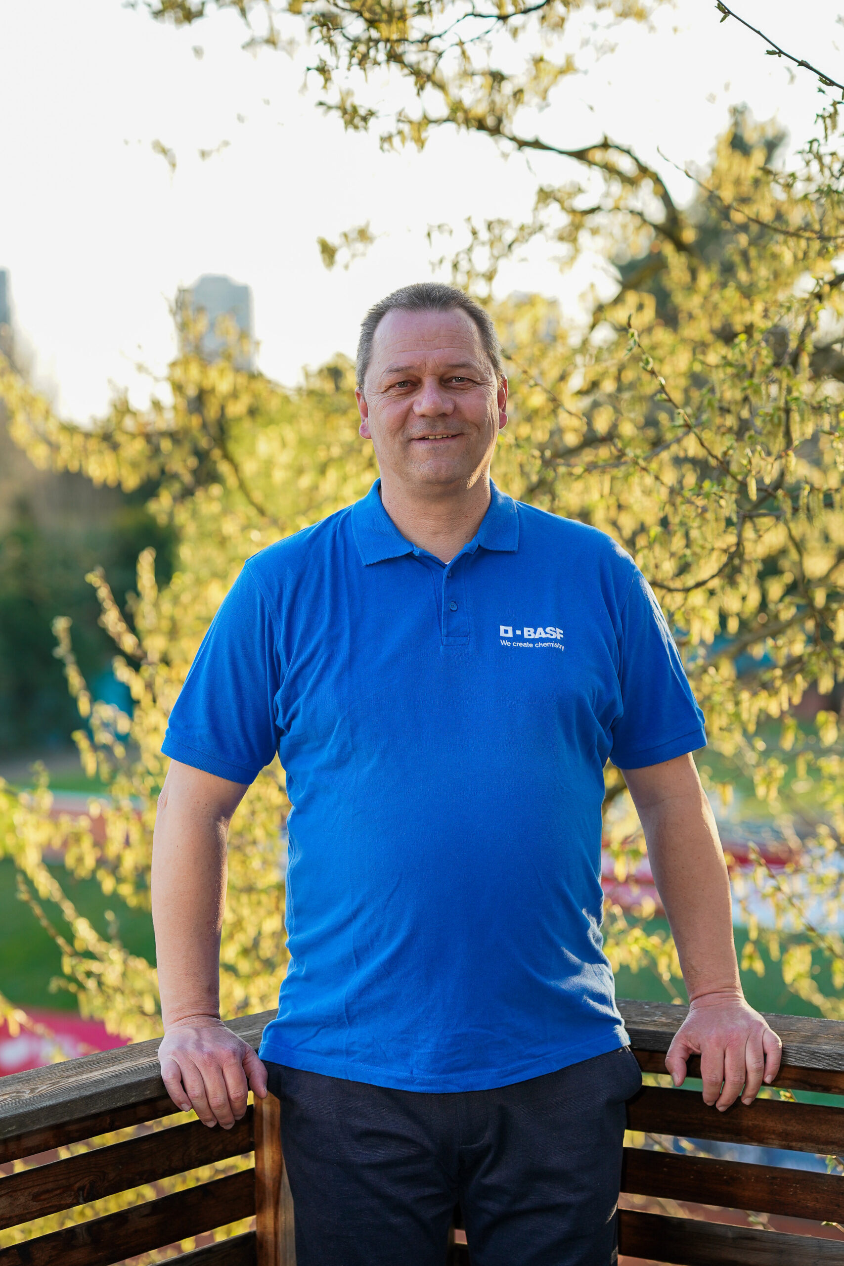 Mann im blauen BASF-Poloshirt im Park