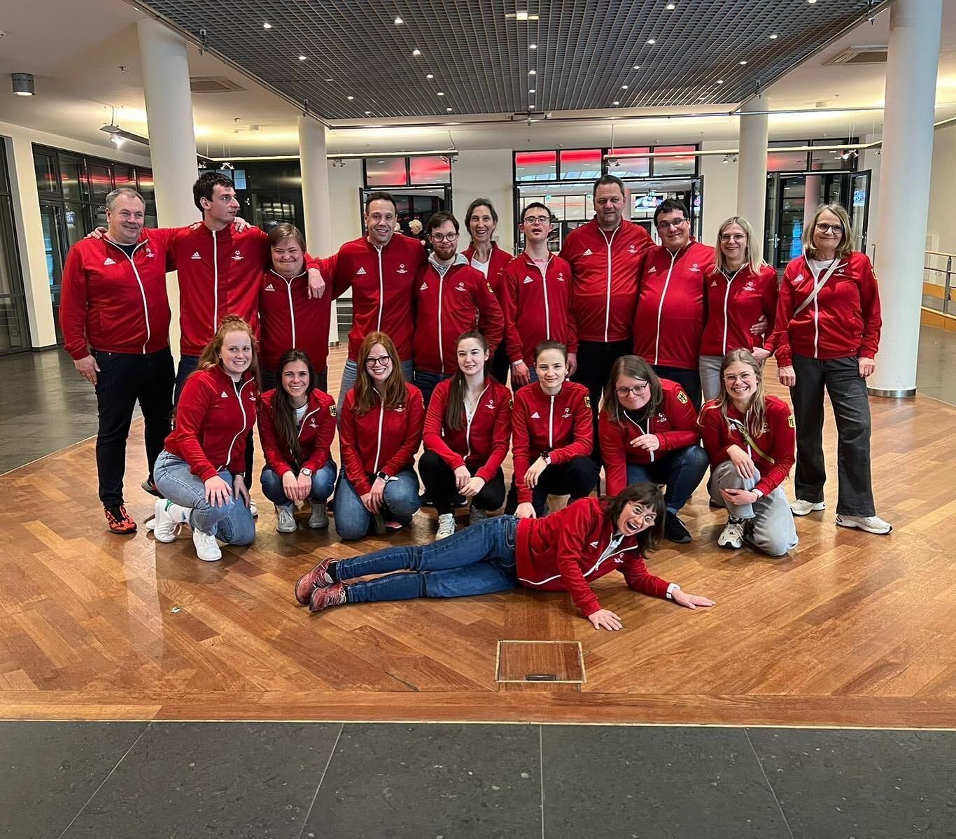 Gruppe im roten Trainingsanzug posiert in Lobby