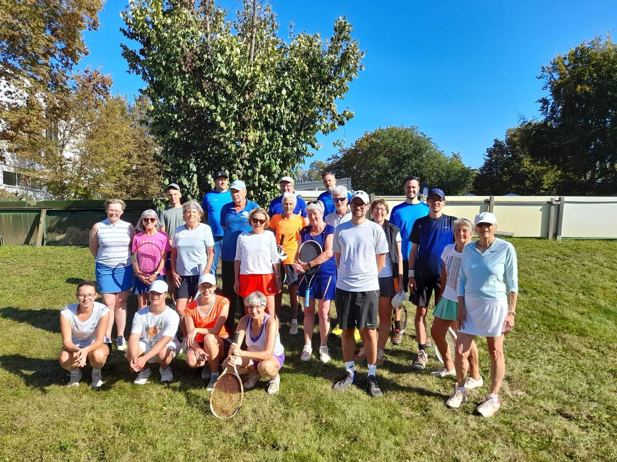 Tennisgruppe auf Rasen bei Sonnenschein