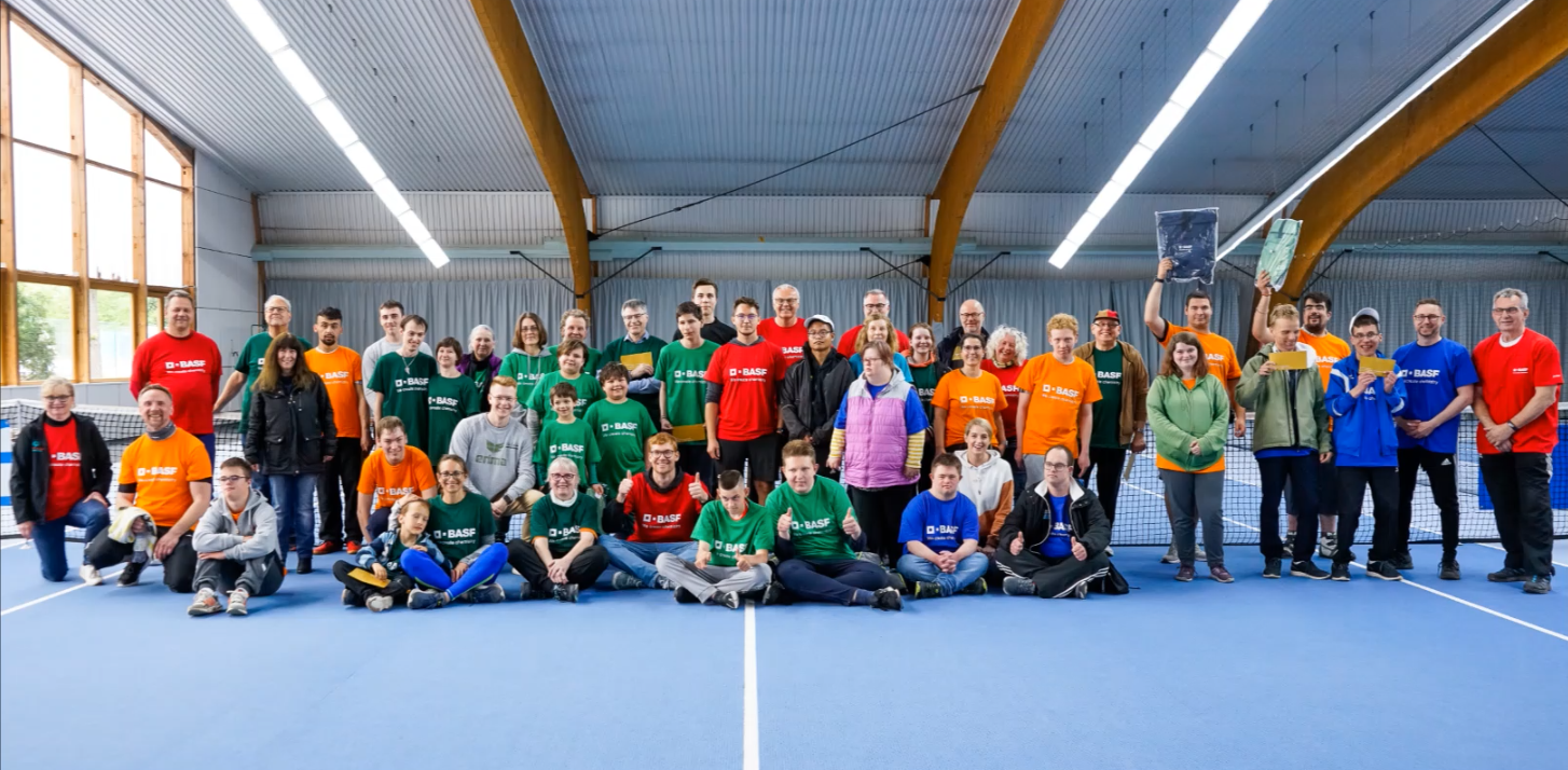 Große Gruppe in Sporthalle mit bunten T-Shirts