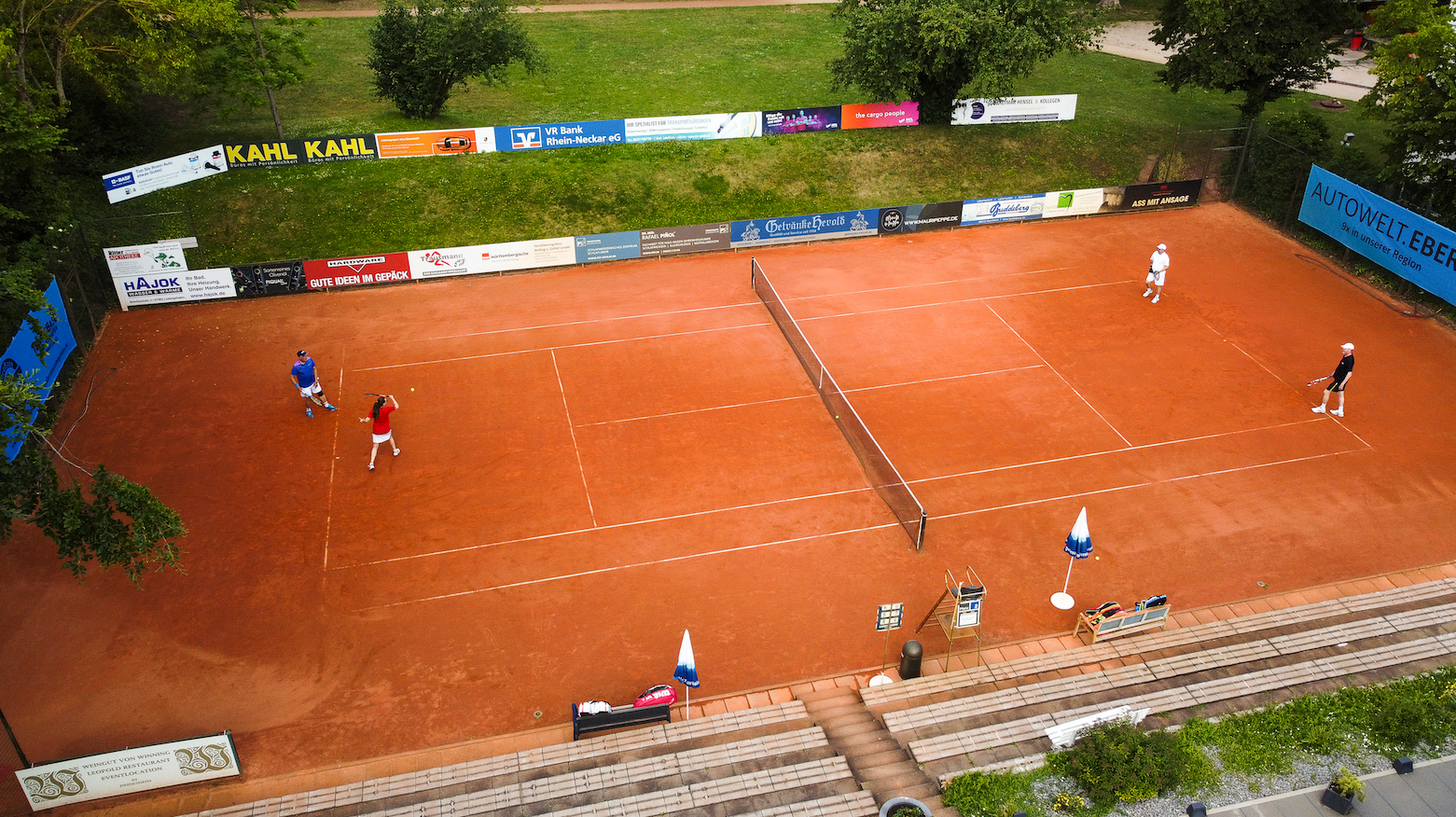 Luftaufnahme eines Tennisspiels auf Sandplatz