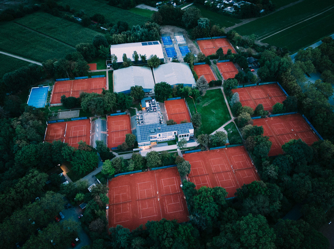 Luftaufnahme einer Tennisanlage mit vielen Sandplätzen