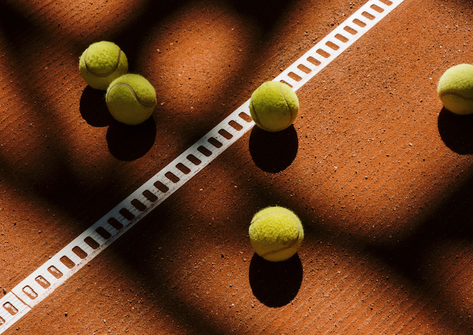Tennisbälle auf Sandplatz mit Linienmarkierung