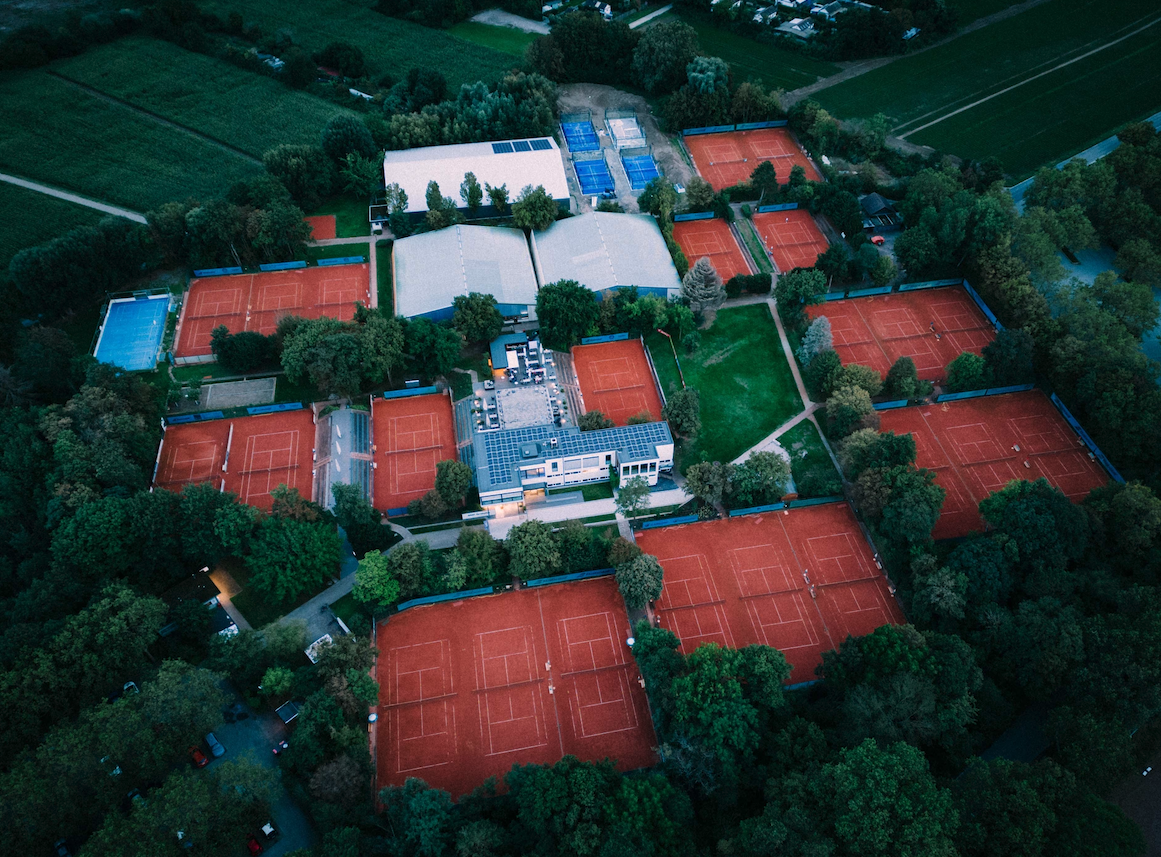 Luftaufnahme einer Tennisanlage mit vielen Sandplätzen