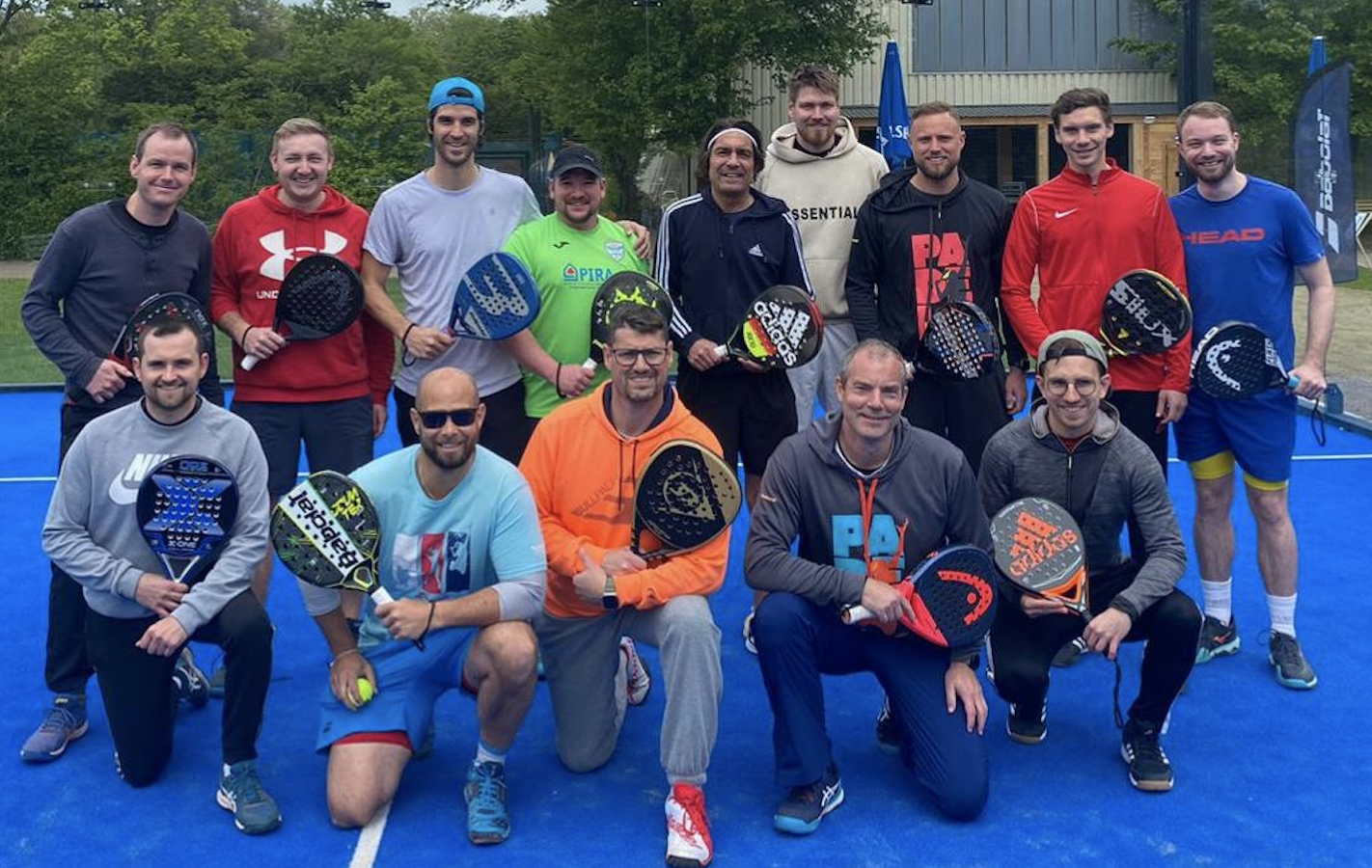 Gruppe von Männern mit Padel-Schlägern auf Court