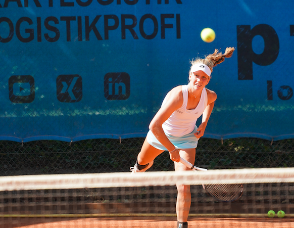Tennisspielerin beim Aufschlag auf Sandplatz