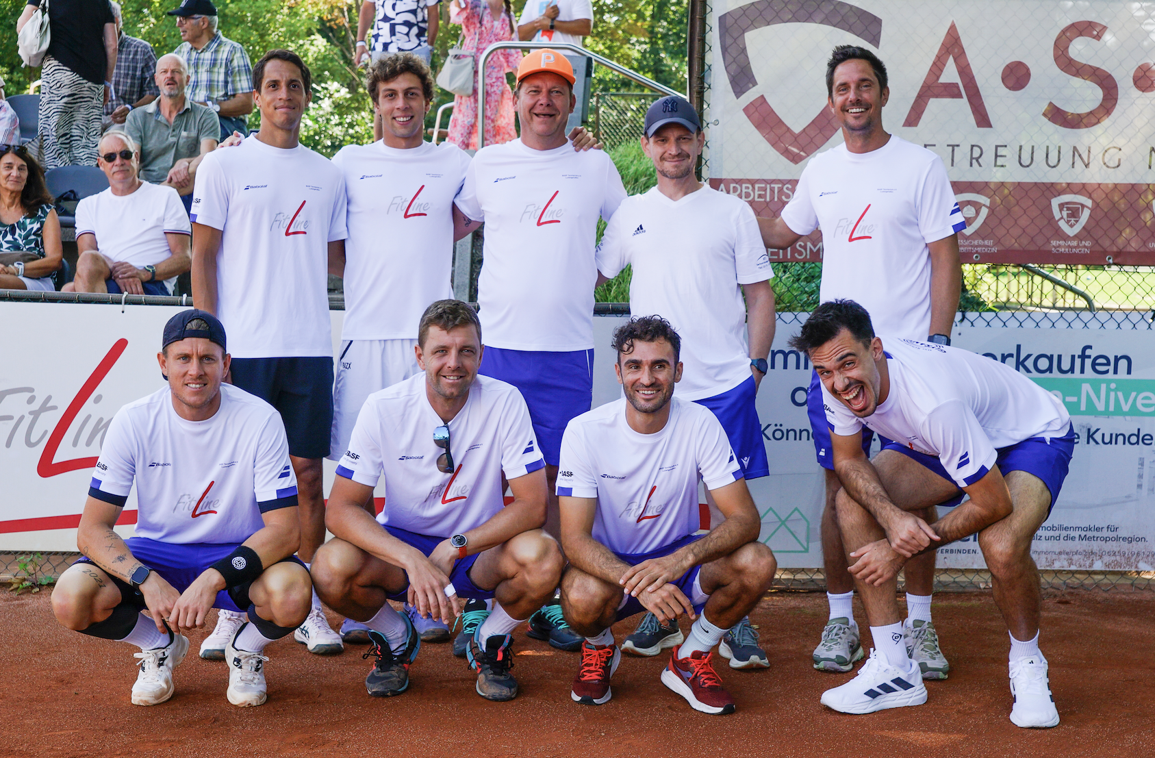 Herren-Tennisteam posiert auf Sandplatz
