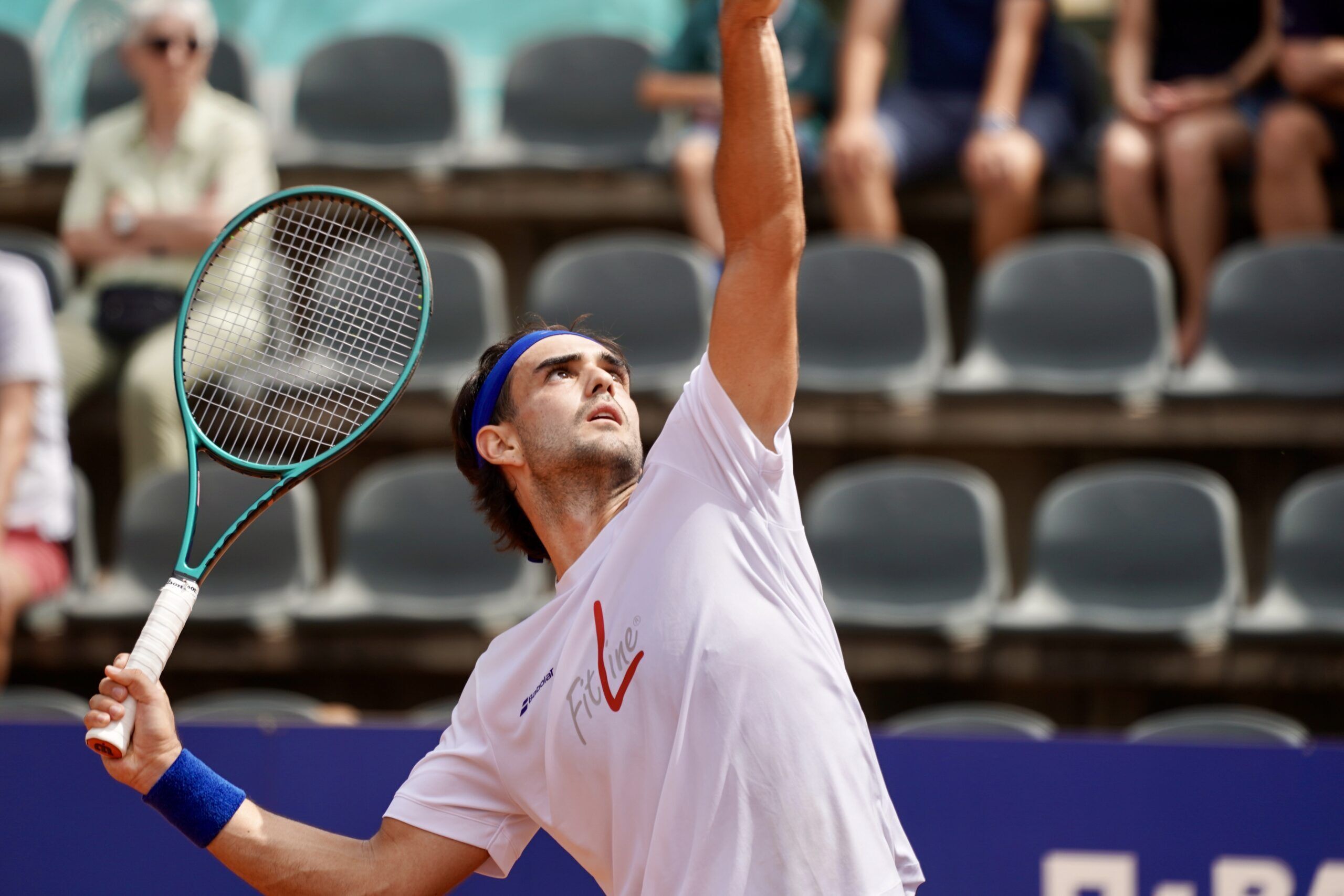 Tennisspieler beim Aufschlag auf Sandplatz