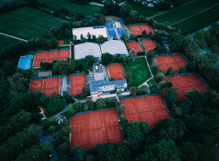 Luftaufnahme einer großen Tennisanlage mit Sandplätzen