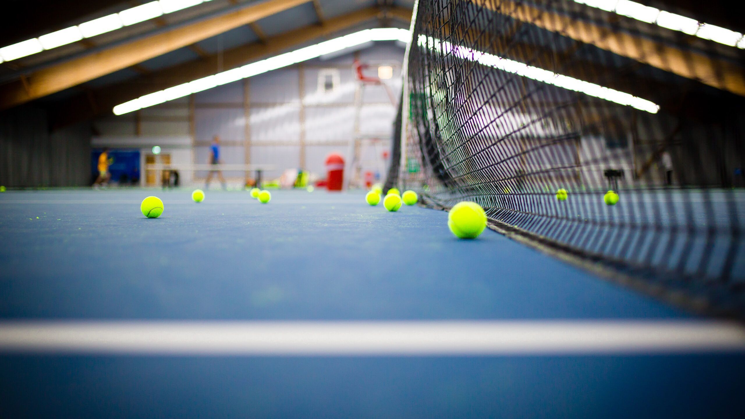 Tennisbälle auf Hallenplatz am Netz