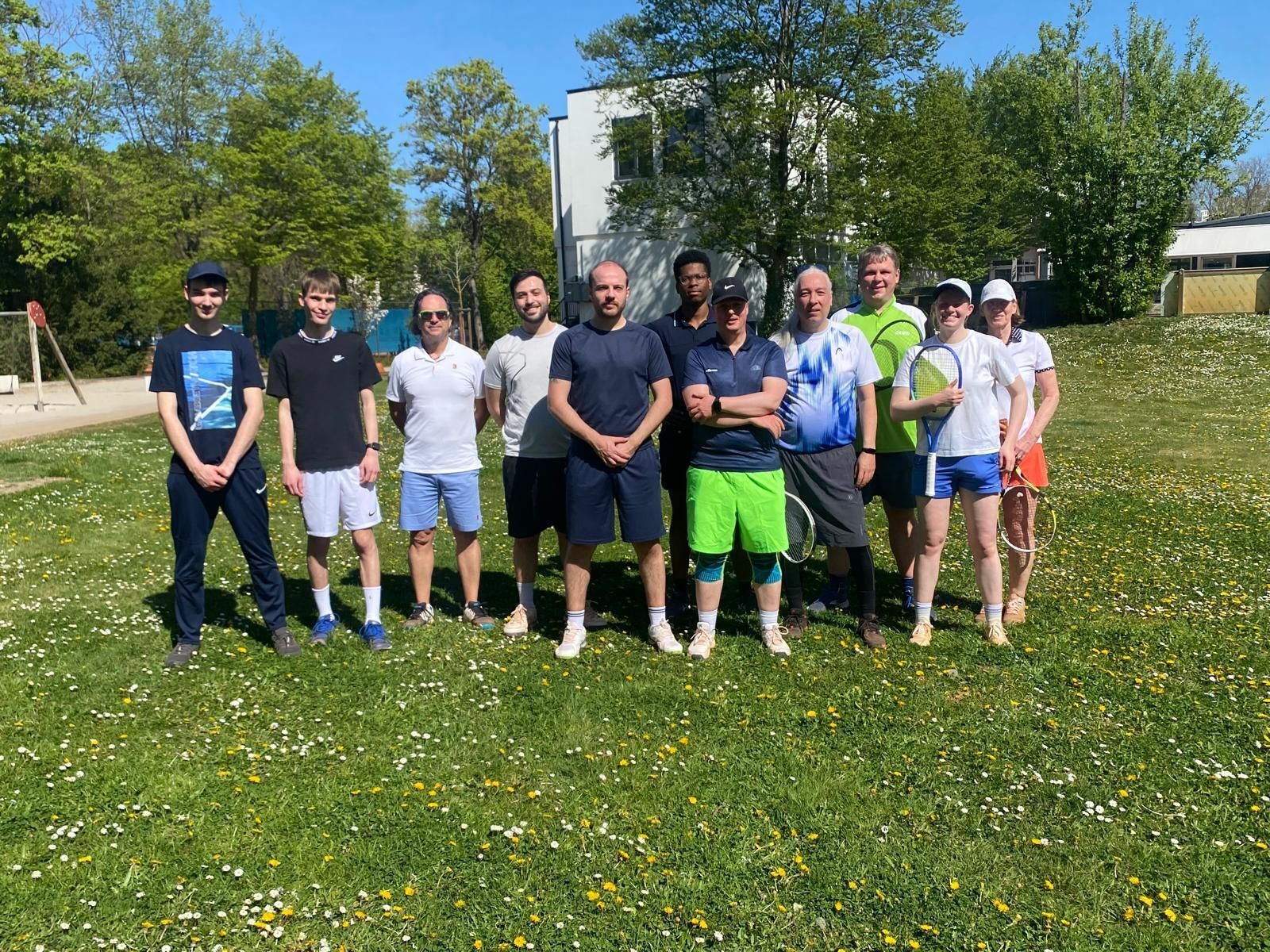 Tennisgruppe im Park mit Schlägern bei Sonnenschein