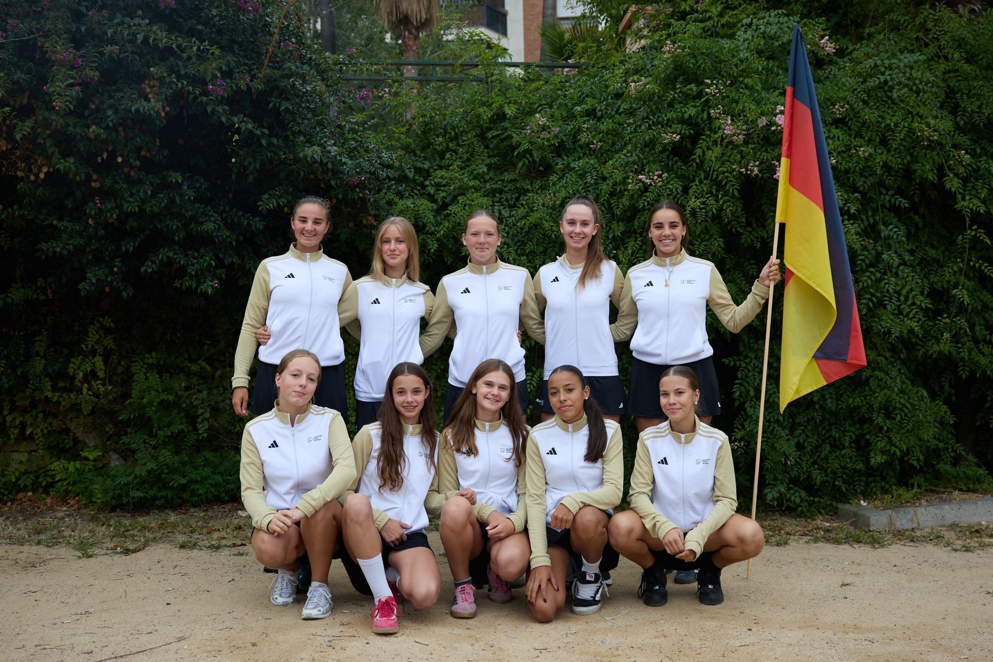 Jugendliches Mädchenteam mit deutscher Flagge im Freien