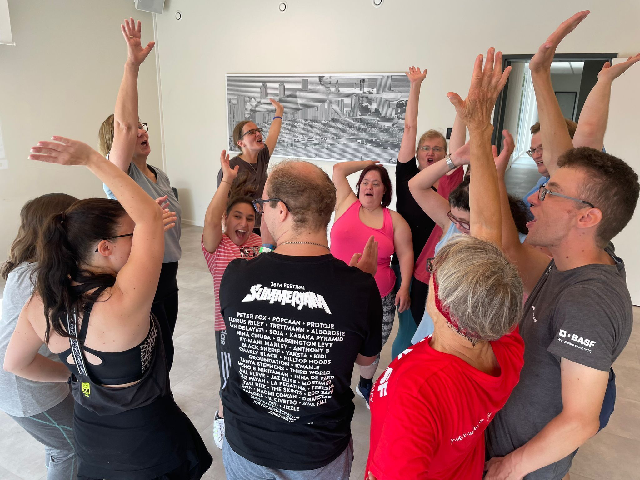 Gruppe von Menschen hebt Arme im Kreis