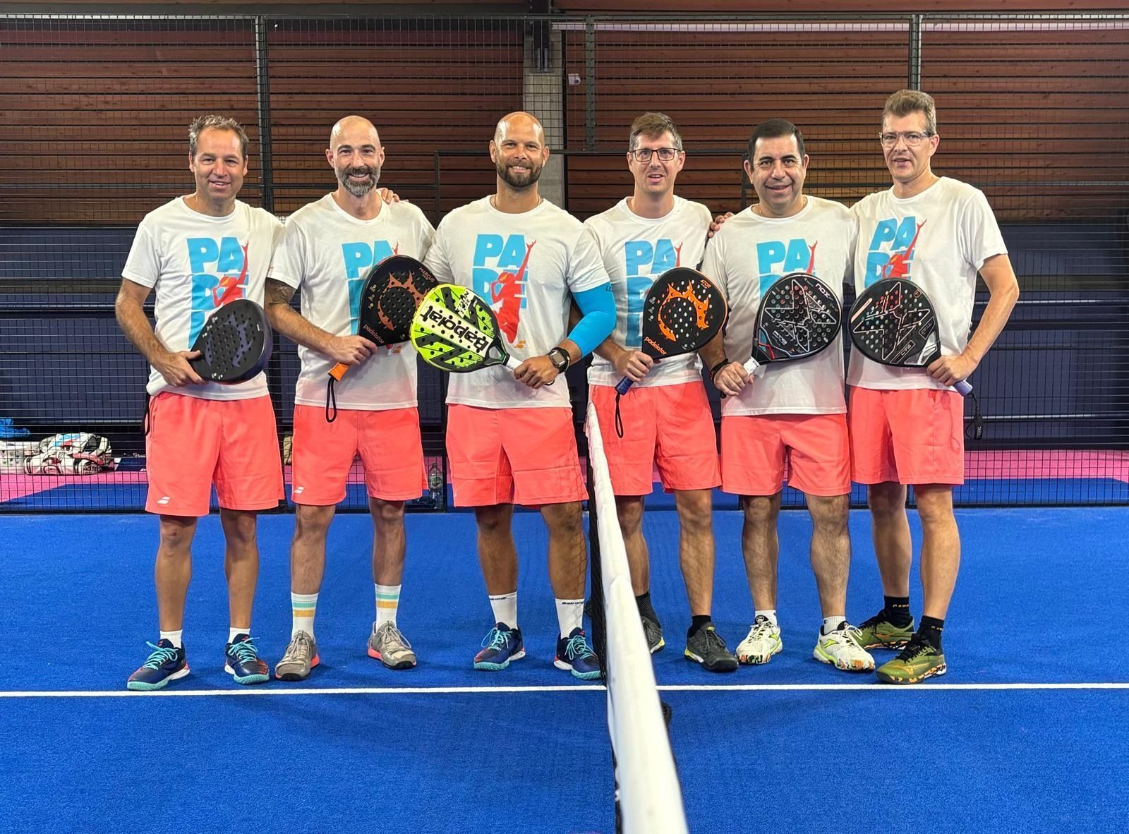 Sechs Männer mit Padelschlägern auf Indoor-Court