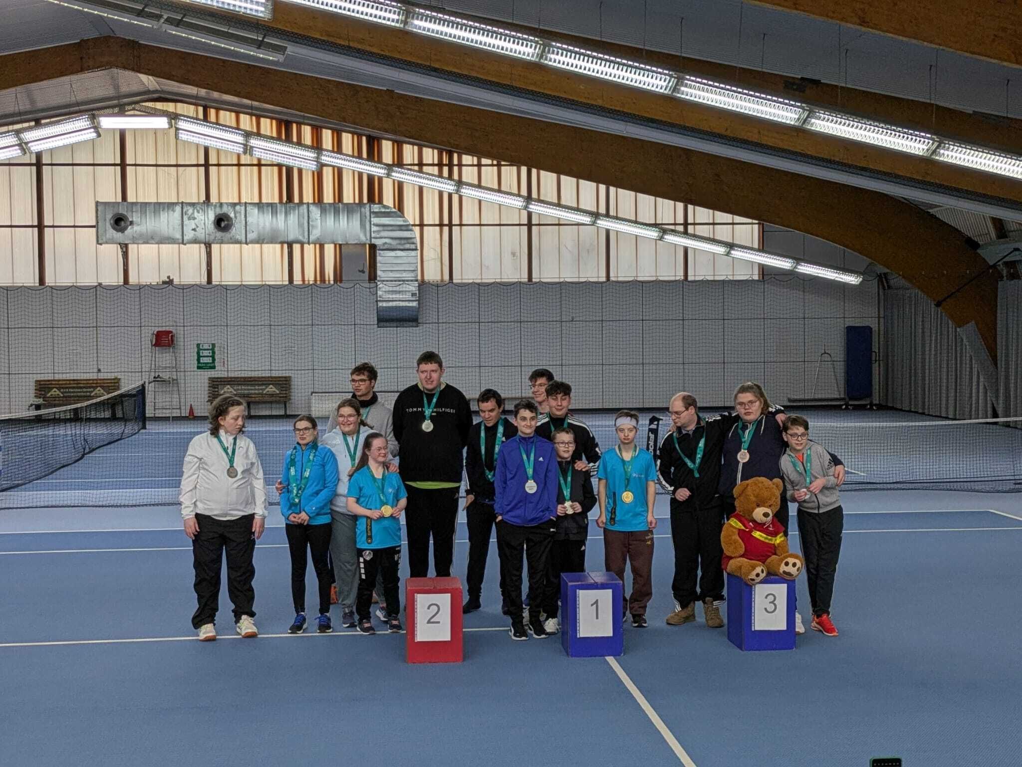 Siegerehrung auf Tennisplatz mit Jugendlichen und Medaillen
