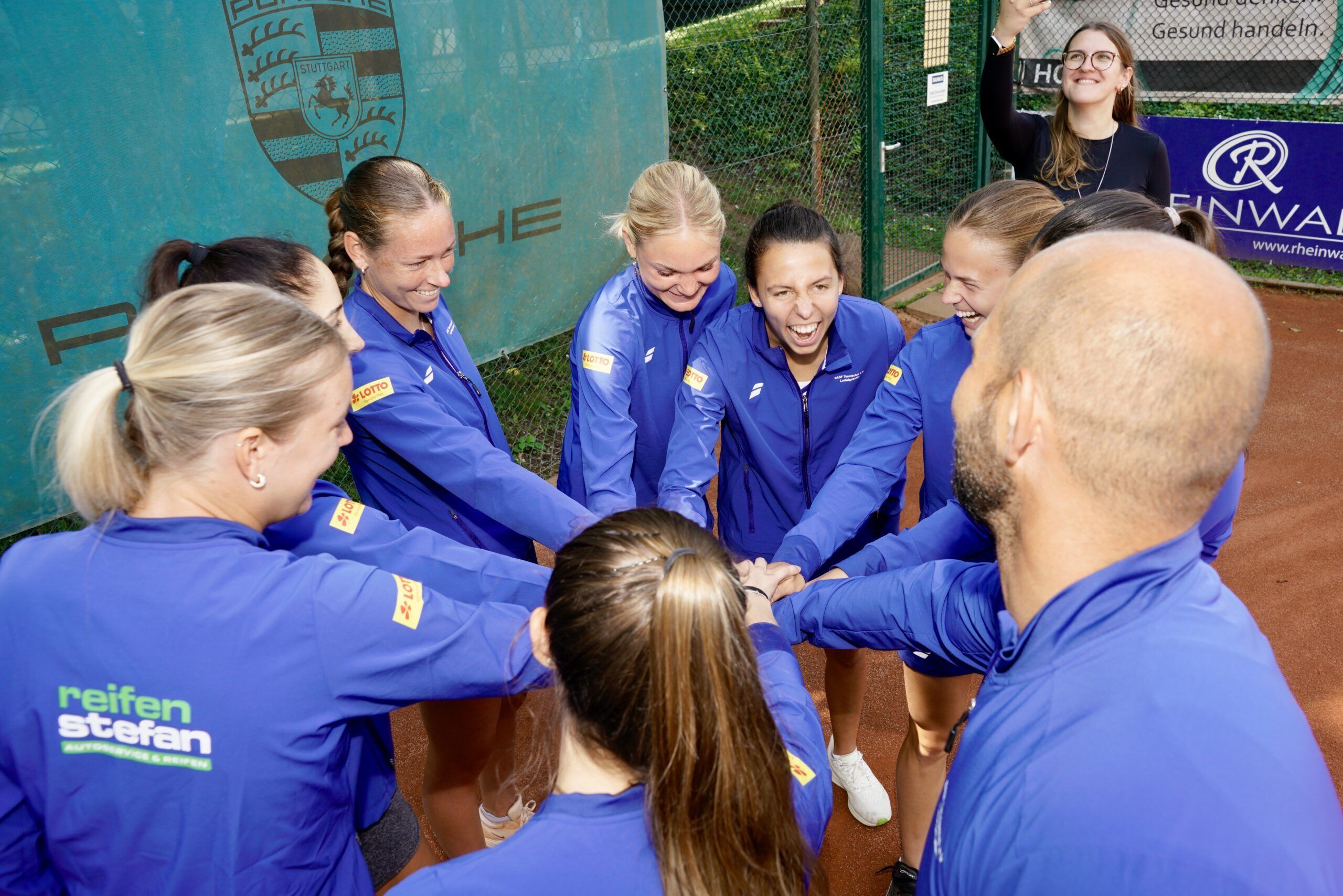 Tennisteam im Kreis mit Händen zusammen